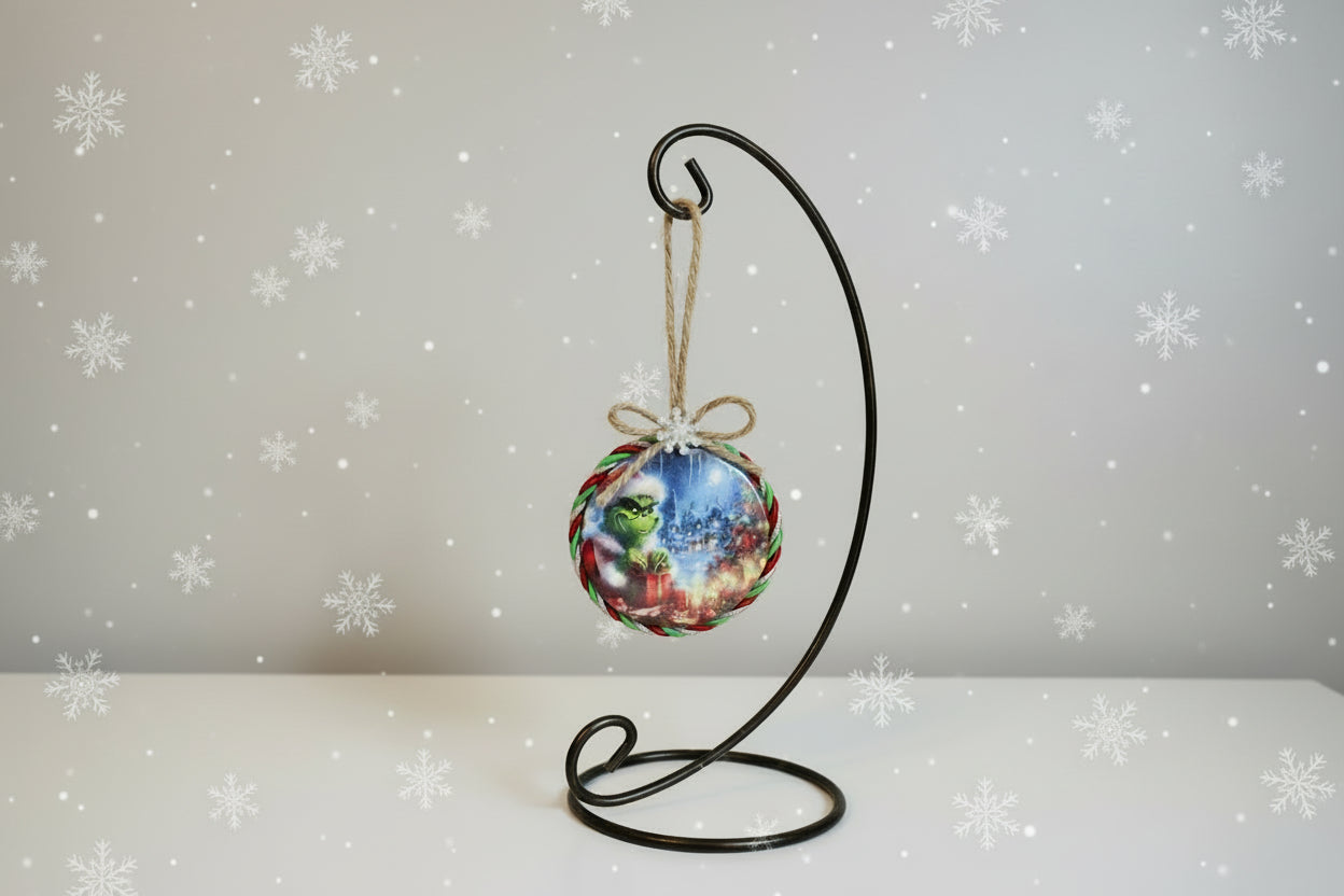 Christmas ornament with Grinch design and festive elements on a white background