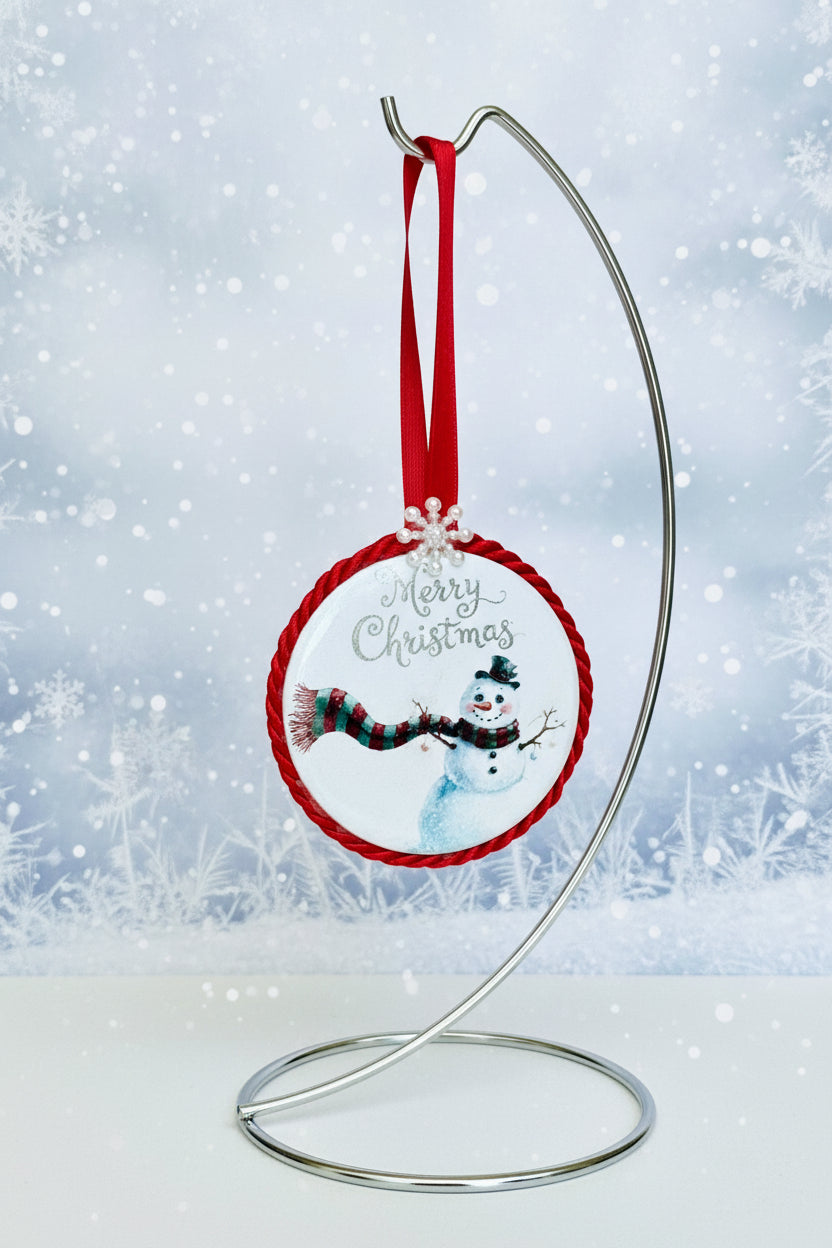Christmas ornament with snowman design and 'Merry Christmas' text on a white background